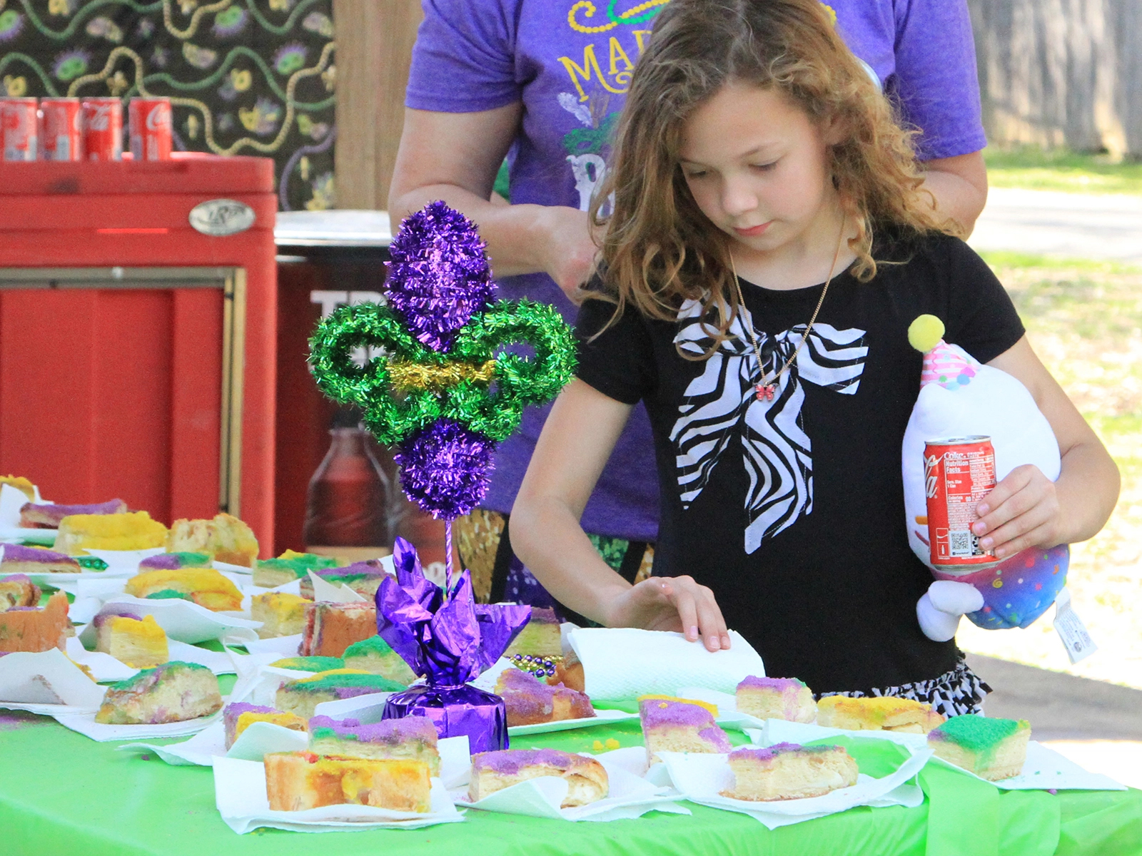 girl selecting piece of king cake