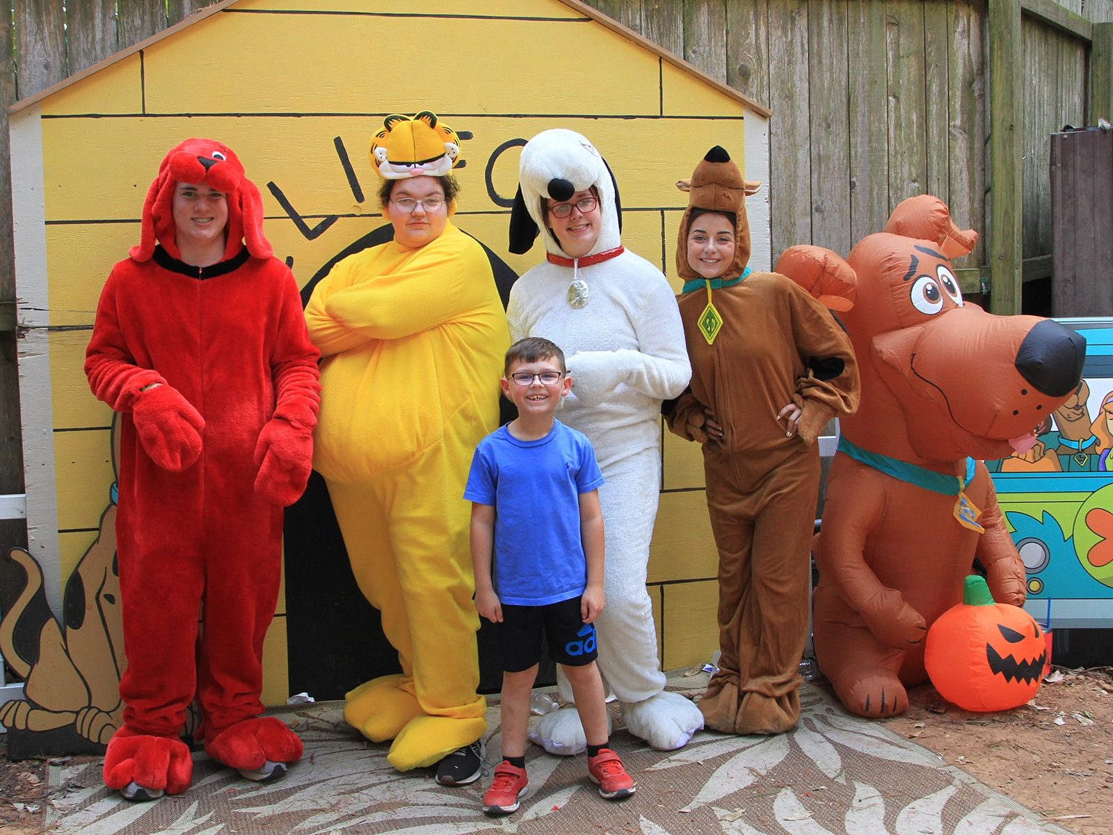 students in costume posing with child