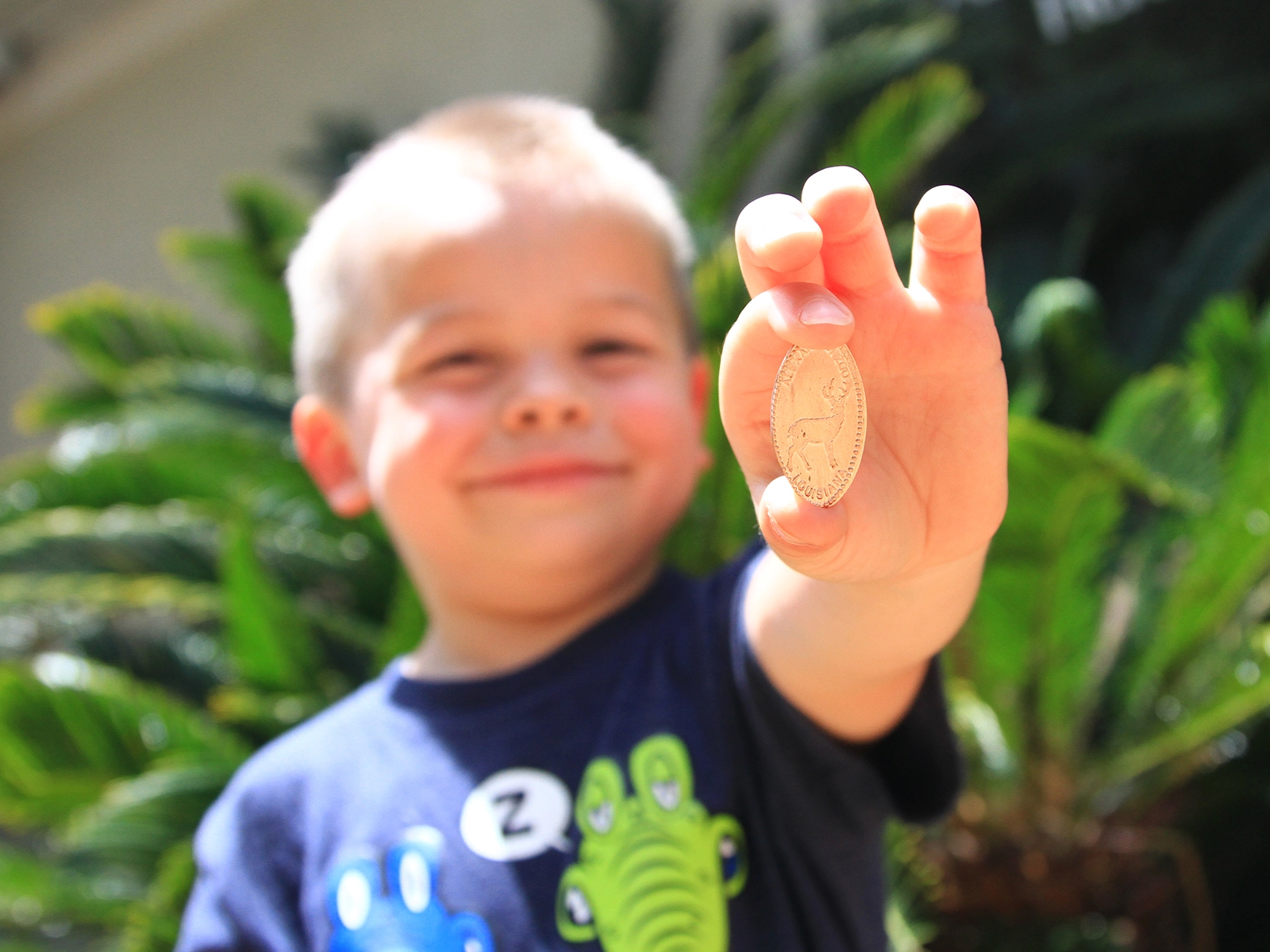 boy holding pressed penny souvenir